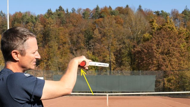 racket handle pushes against the wrist