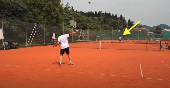 Using a one handed backhand to return a slow tennis serve down the T.